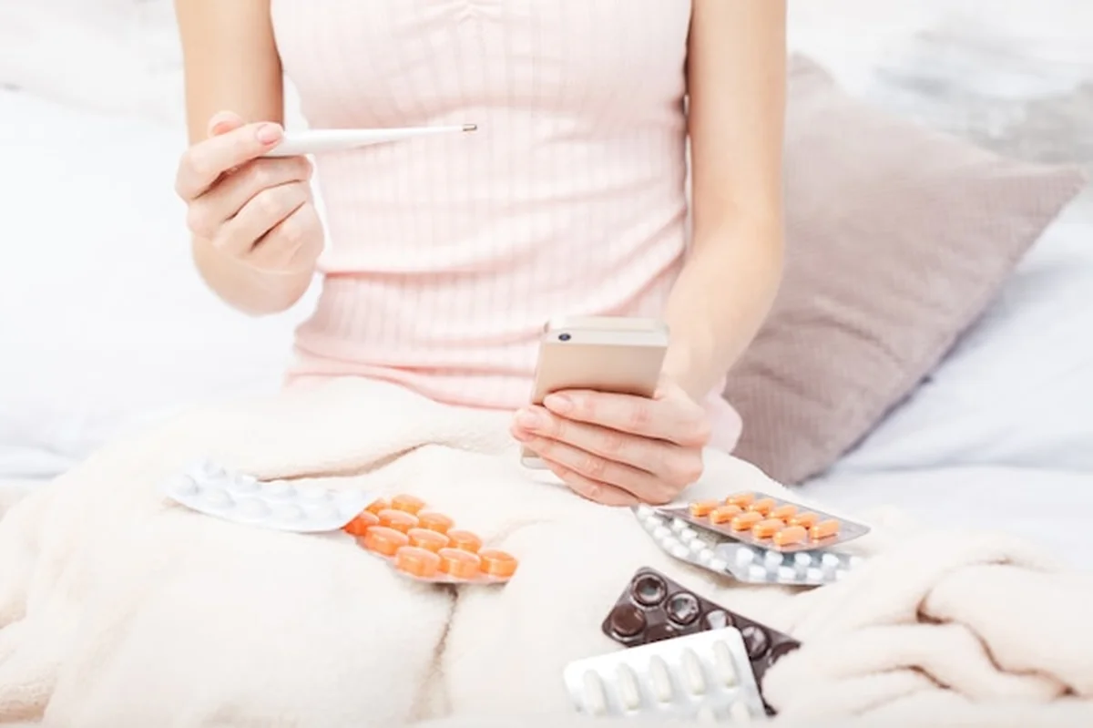 Chora młoda kobieta z wysoką gorączką, leżąc w łóżku