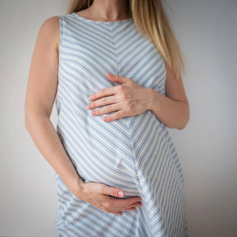 Kobieta w ciąży trzymająca ręce na brzuchu