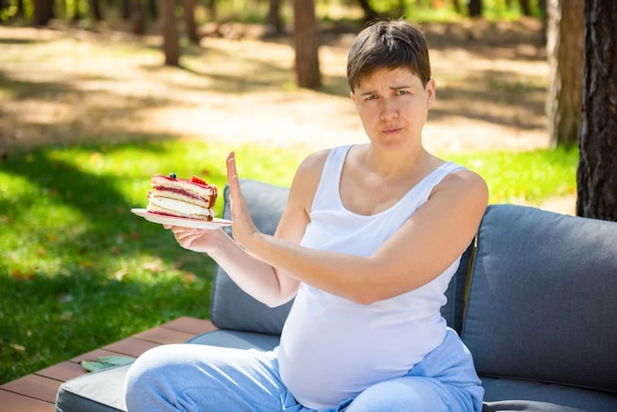Kobieta w ciąży unika słodkiego ciasta