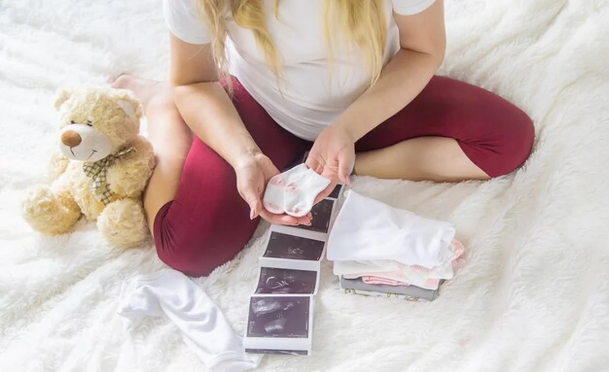 Kobieta w ciąży trzyma migawkę USG