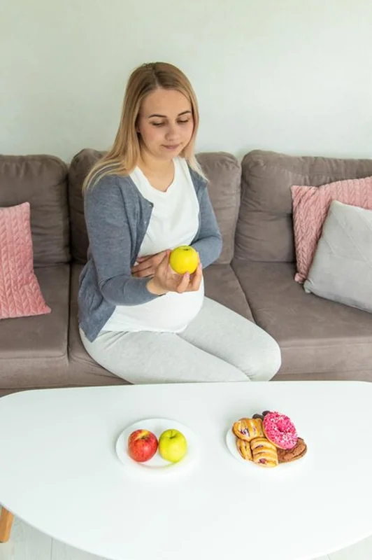 Kobieta w ciąży zjada jabłko